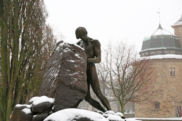 Karl Hultströms skulptur Befriaren i Centralparken i Örebro med slottet i bakgrunden.